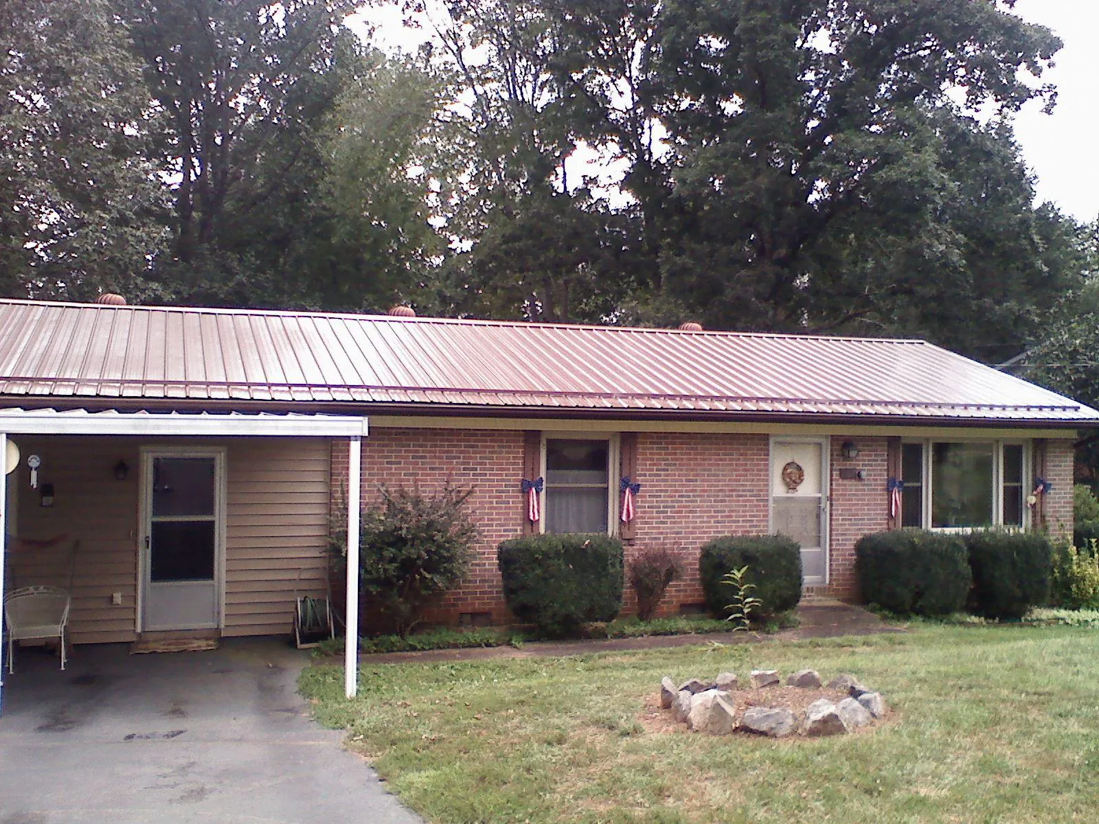 Bronze metal roof and carport on a brick ranch home — Roof Repair work by our crew in Gulfport