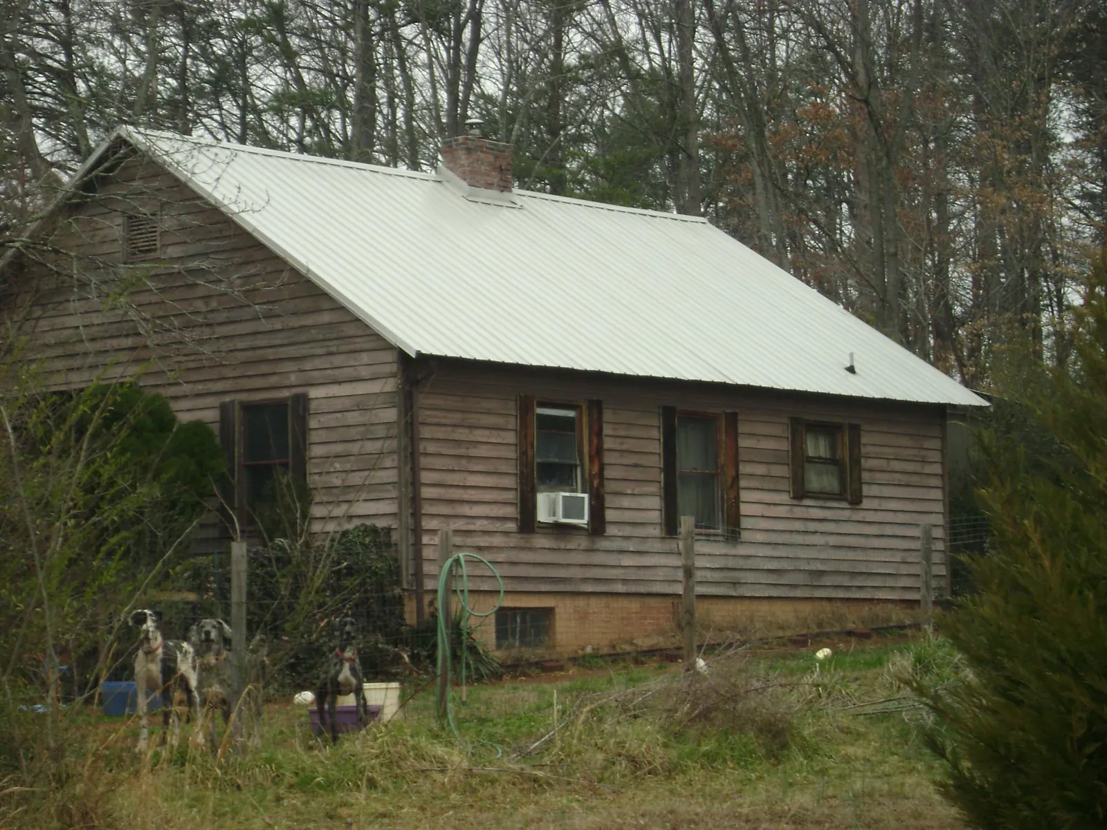 White metal roof on an old wood sided farmhouse, from a Asphalt Shingle Roof Repair job in Gulfport